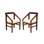 A pair of solid wood armchairs with a honey finish and beige cushions.
