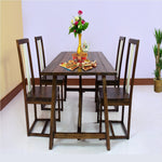 A solid wood dining table with four chairs arranged around it in a dining room setting. The table is rectangular, and the chairs are matching with a simple design.