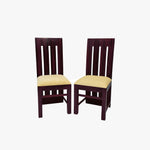 A pair of wooden dining chairs with a walnut finish and padded seats in a room setting.