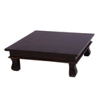 A rectangular solid wood pooja choki with curved legs, finished in a dark stain.