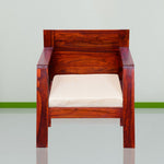 A wooden single seater sofa with a beige cushion, placed against a neutral background.