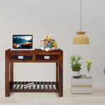Wooden console table with a laptop, books, and decorative items in a living room setting.