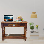 Wooden console table with a laptop, books, and decorative items in a living room setting.