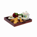A wooden breakfast tray with a maple finish, including a teapot, cups, and a serving dish with snacks.