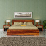 Wooden bed with green bedding in a room with green walls and decorative elements.