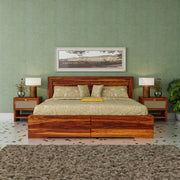 Wooden bed with green bedding in a room with green walls and decorative elements.