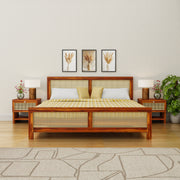 Wooden bed with wicker design in a bedroom setting with lamps and decor.