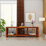 Wooden console table in a living room with decor items and a lamp.