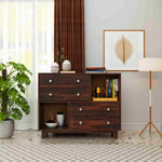 Wooden dresser with multiple drawers in a room with decor elements like a plant, lamp, and framed picture.