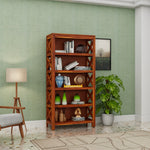 Wooden bookshelf with decorative items against a green wall in a room.