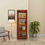 Wooden bookshelf in a living room with decor items and a plant.