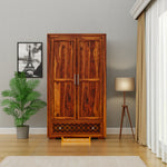 Wooden wardrobe in a room with a lamp and plant, branded 'Furniseworlds'.