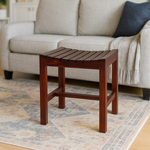 Wooden side table in front of a gray sofa in a living room setting.