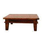 A wooden pooja chowki in maple finish with intricate designs, made from Sheesham Wood, with a flat surface and raised edges.