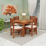Wooden dining table set with chairs in a room with a painting and lamp.