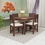 Dining room with wooden table and chairs against a green wall.