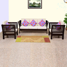 A walnut finish solid wood 5 seater sofa set consisting of three single sofas and two armchairs, with beige cushions and multicolored throw pillows, placed in a room with a carpet.