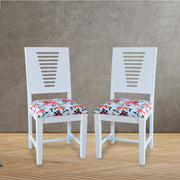 A pair of white wooden dining chairs with a floral fabric seat cushion.