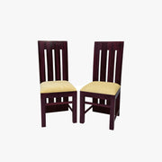 A pair of wooden dining chairs with a walnut finish and padded seats in a room setting.