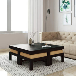 A wooden coffee table with a walnut finish and four attached stools with cushions in a living room setting.