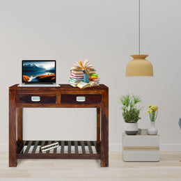 Wooden console table with a laptop, books, and decorative items in a living room setting.
