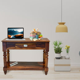 Wooden console table with a laptop, books, and decorative items in a living room setting.