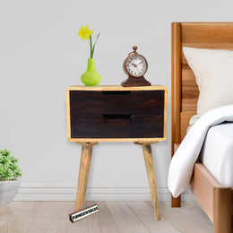 Wooden nightstand with decorative items next to a bed in a bedroom setting.
