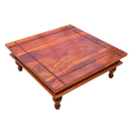 A rectangular wooden pooja chowki with a maple finish, featuring intricate Indian designs and made from Sheesham wood.