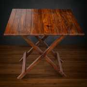 Wooden folding table on a wooden floor with a dark background