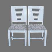 A pair of white wooden dining chairs with patterned fabric seats, viewed from the back.