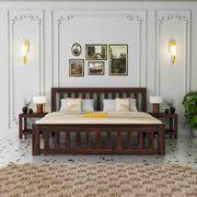Wooden bed in a bedroom with decorative wall art and lighting.