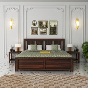 Wooden bed with green and white patterned bedspread in a bedroom setting.
