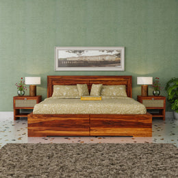 Wooden bed with green bedding in a room with green walls and decorative elements.