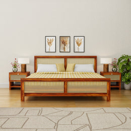 Wooden bed with wicker design in a bedroom setting with lamps and decor.
