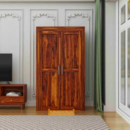 Wooden wardrobe in a room with a television and small table.