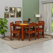 Wooden dining table set with chairs in a room with decor elements.