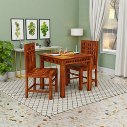 Wooden dining table and chairs in a room with green walls and a window.