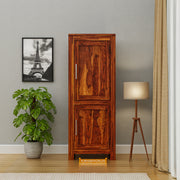 Wooden cabinet in a room with a plant, lamp, and framed picture of the Eiffel Tower.