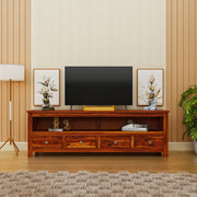 Wooden TV stand with a television in a living room setting.