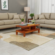 Living room with beige sofas, a wooden coffee table, and a patterned rug.