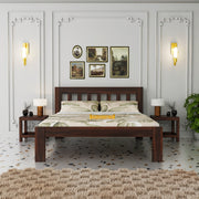 Wooden bed in a bedroom with decorative wall art and lighting.