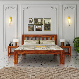 Wooden bed in a bedroom with decorative wall art and lighting.