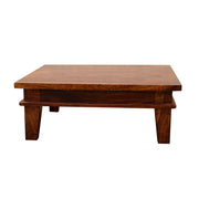 A wooden pooja chowki in maple finish with intricate designs, made from Sheesham Wood, with a flat surface and raised edges.