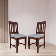 Two wooden chairs with light blue cushions on a wooden floor.