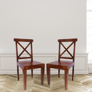 Two wooden chairs with a cross-back design on a wooden floor.
