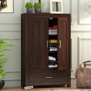A wooden bookshelf with drawer storage in a walnut finish, placed in a living room setting with various decorations around it.