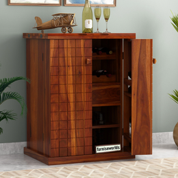 A wooden bar cabinet with glass doors, displaying a wine rack inside, placed against a wall with a potted plant and decorative items.