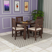 Dining room with a wooden table and chairs against a purple wall with framed pictures.
