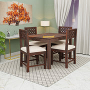 Dining room with wooden table and chairs against a green wall.